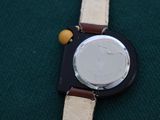a close up of a watch on a green surface