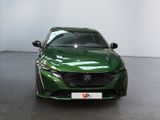 the front of a green car in a showroom with a white wall