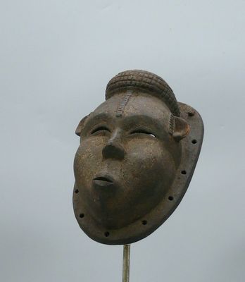une statue représentant un homme coiffé d'un chapeau, au sommet d'un poteau