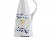 white ceramic jug with a drawing of a man ' s face on it