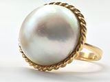 une photo d'une bague ornée d'une perle blanche