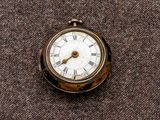 une petite montre de poche ornée de chiffres romains