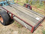 a trailer with a wooden cart attached to it in the grass