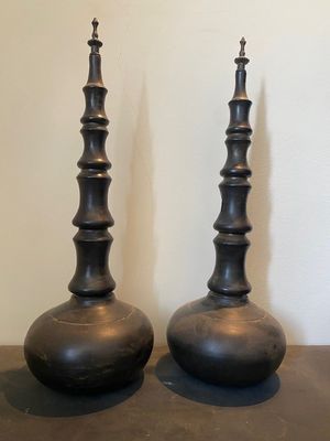 deux vases noirs posés l'un à côté de l'autre sur une table