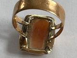 une image représentant une bague en or sertie d'une pierre orange