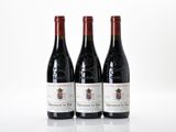 three bottles of wine sitting on top of a white table