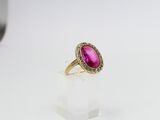 a pink tourmaline and diamond ring on a clear acrylic stand