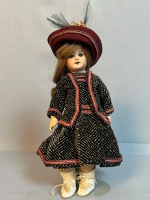 une poupée qui porte une robe et un chapeau