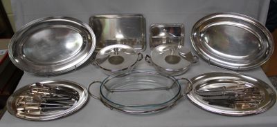 a lot of silver plates and pans sitting on a table