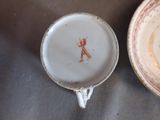 a cup and saucer sitting on a table next to a plate