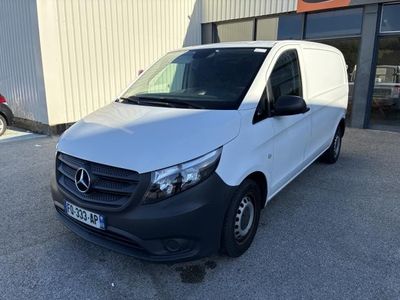 une camionnette blanche garée devant un bâtiment dans un parking