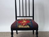 une chaise noire avec une assise rouge et bleue