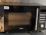 a black microwave sitting on a counter top with a price tag on it