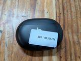 des AirPods noirs posés sur une table en bois