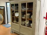 a cabinet with a glass door in the middle of a room