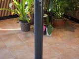 a black pole with a clock on it on a tiled floor