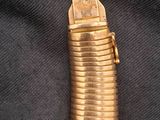 une photo d'un briquet doré posé sur un tissu noir