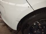 a close up of a car ' s front tire with a hole in the tire