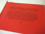 an open book with a red cover on a white table