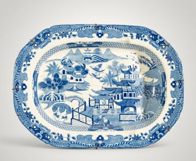 un plat bleu et blanc orné d'un paysage