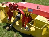 a red and yellow machine that is sitting in the grass