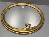un miroir doré sur lequel est assise une femme