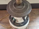 a black and white vase sitting on a wooden floor