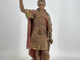 statue d'un homme tenant une croix dans la main droite et une autre croix dans la main gauche