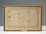 an old manuscript with a gold frame on a white table