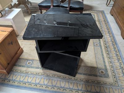 a black desk with a black chair in the corner of the room