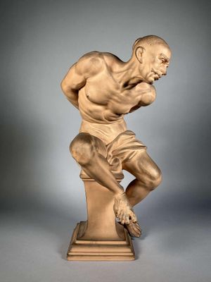 une image représentant la statue d'un homme assis au sommet d'un piédestal