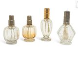 trois petits flacons de parfum sont alignés sur une surface blanche