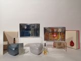 a white table with a vase, a vase, a box, and other items on it