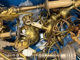 a blue bin filled with brass objects and other items