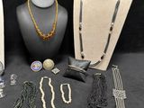 several necklaces, bracelets, and earrings are displayed on a mannequin