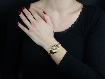 a woman with red nails and a watch on her wrist