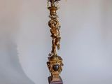 an image of a tall candle holder with a statue on top of it