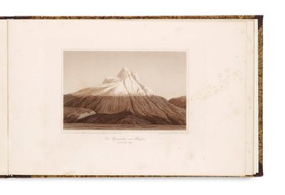 un vieux livre avec une image de montagne en arrière-plan