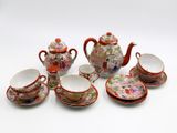 a group of teapots, cups and saucers on a white surface