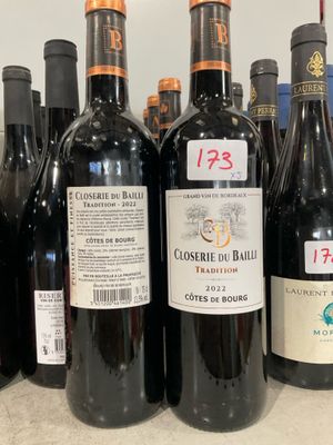 plusieurs bouteilles de vin rouge sont alignées sur une étagère