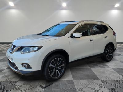 un SUV Nissan blanc garé sur un sol à damier dans un garage