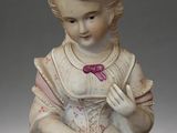 a figurine of a little girl with a pink hat