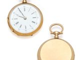 two gold pocket watches sitting next to each other on a white surface