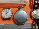 three different types of watches on display in a display case
