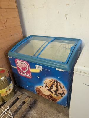 an ice cream machine and a freezer in the corner of a room