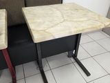 two tables and a bench in the corner of a room