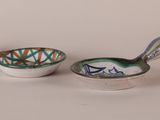 two bowls and spoons sitting next to each other on a table