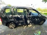 a small black car that is parked on the side of the road