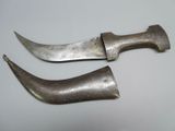 pair of silverware knifes with curved blades on a white surface