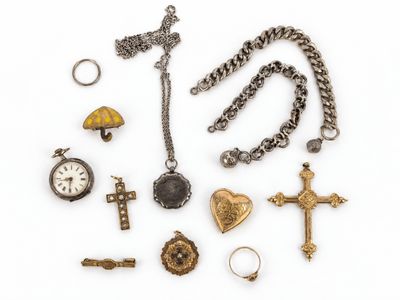 une photo d'une collection de bijoux comprenant une croix, une montre de poche, une bague et un collier